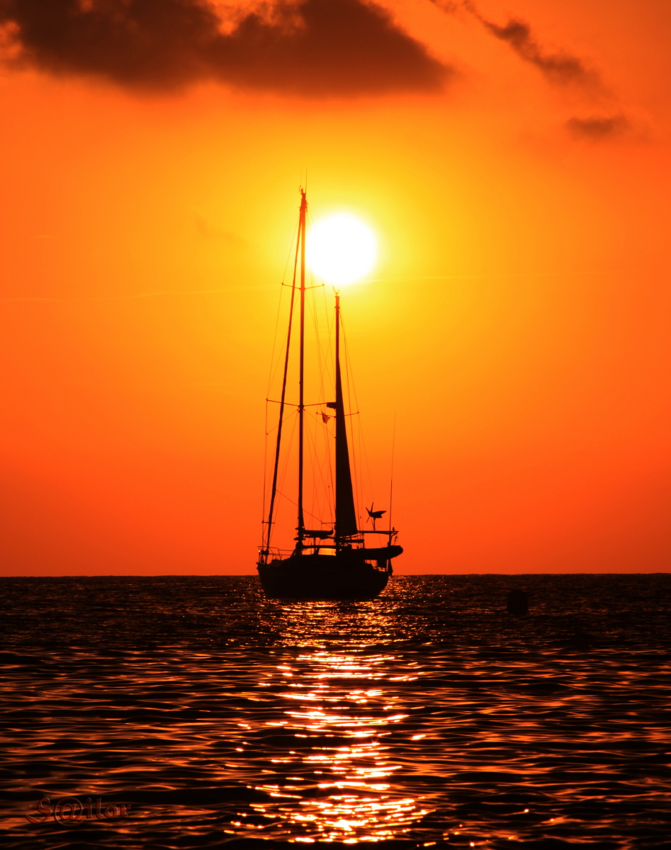A boat sailing into the sunset.