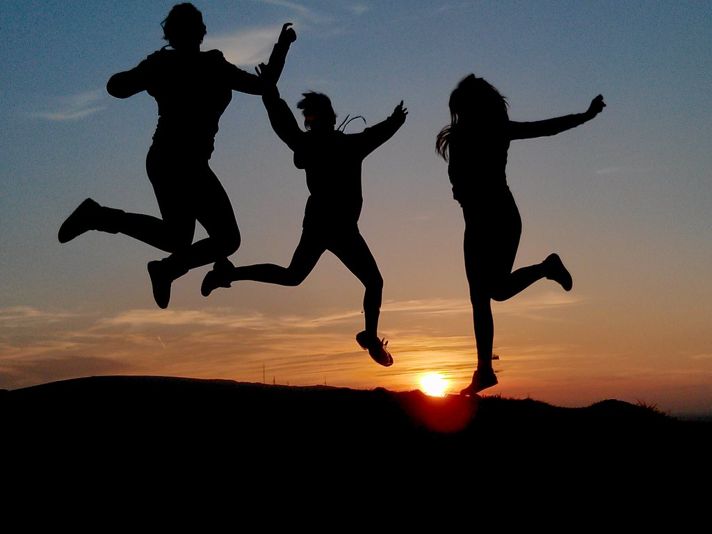 A person jumping for joy with their hands in the air.