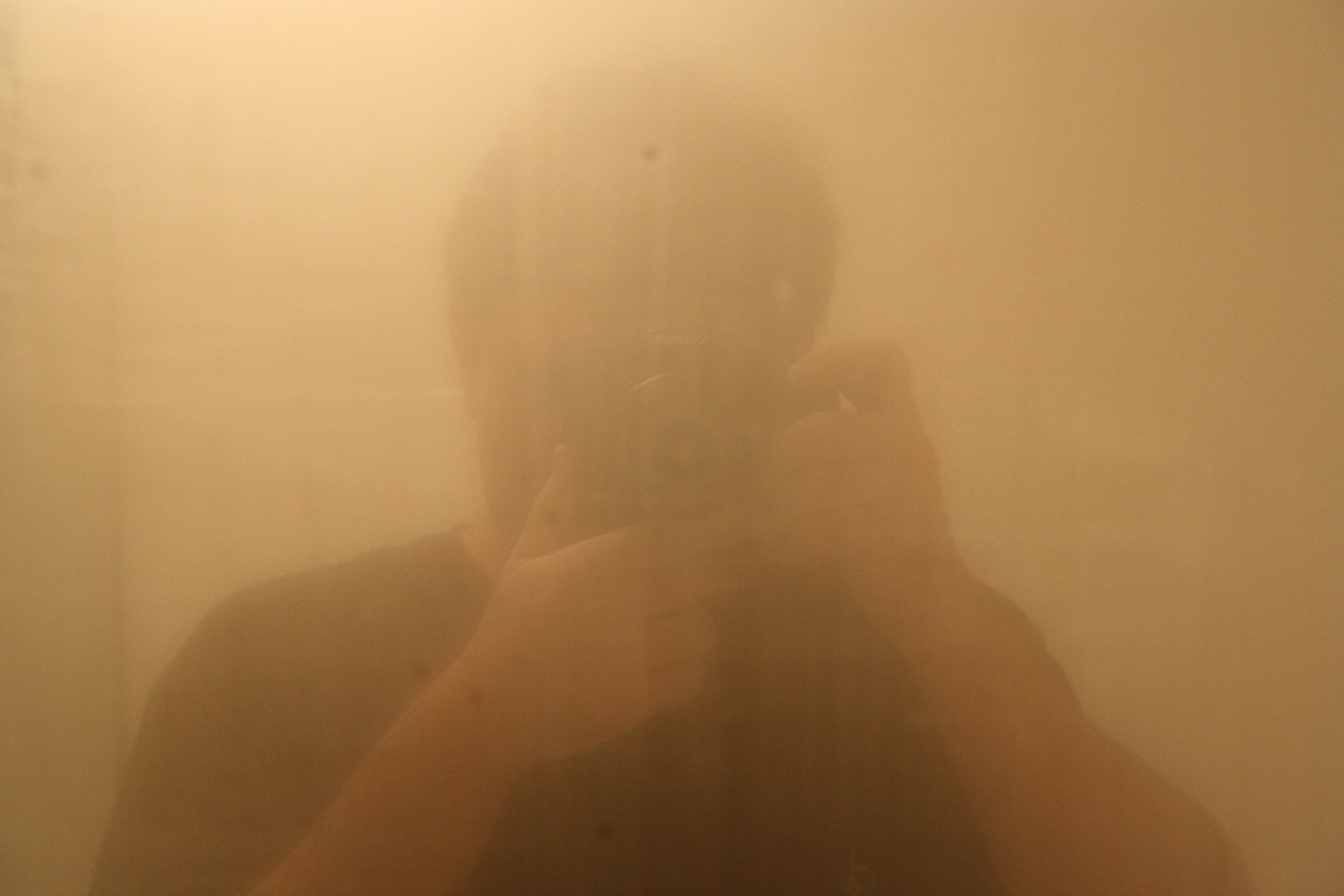 A person looking into a foggy mirror.