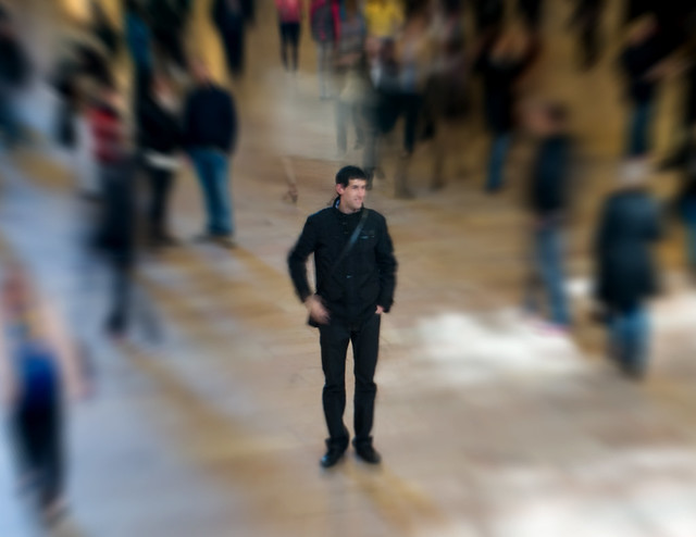 A person standing alone at a crowded party
