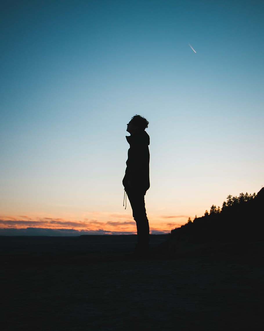 A person standing alone in a dark and desolate landscape.