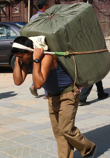 A person struggling to carry a heavy load
