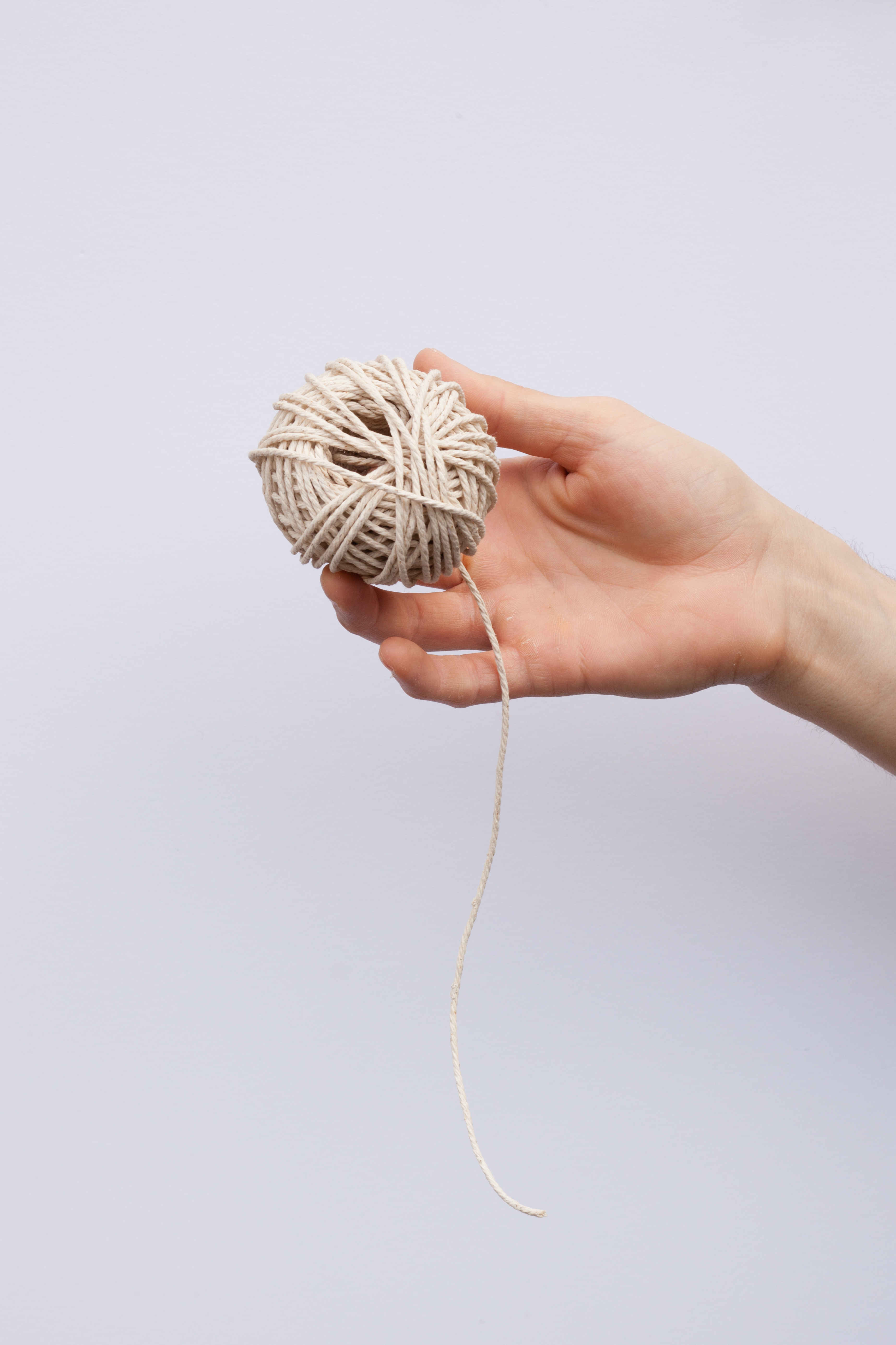 A person unraveling a ball of yarn.