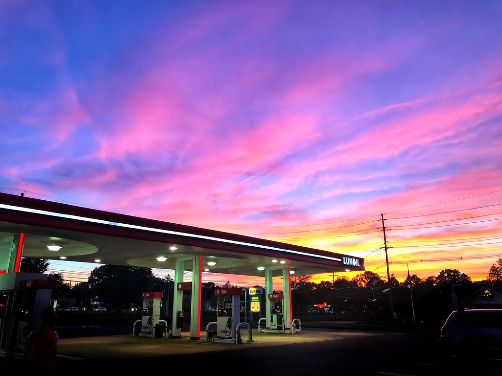 A serene sunset scene at a gas station.