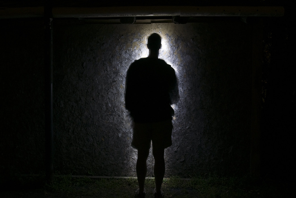 A shadowy figure entering through a window.