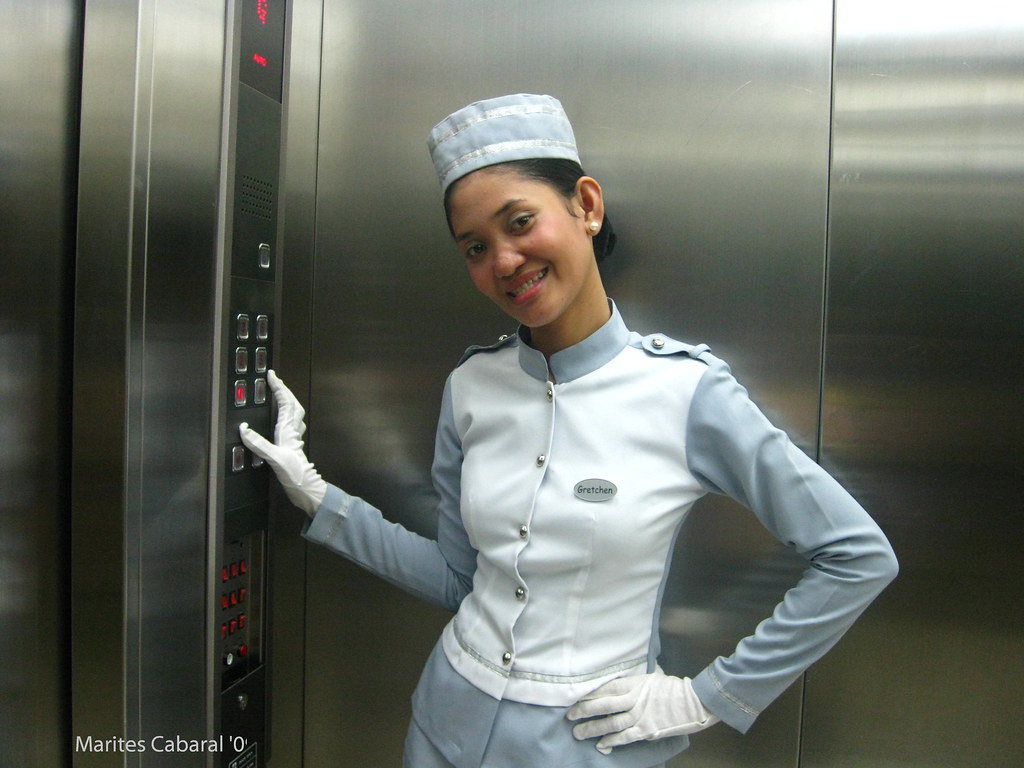 An image of a person stepping out of an elevator with a smile on their face.