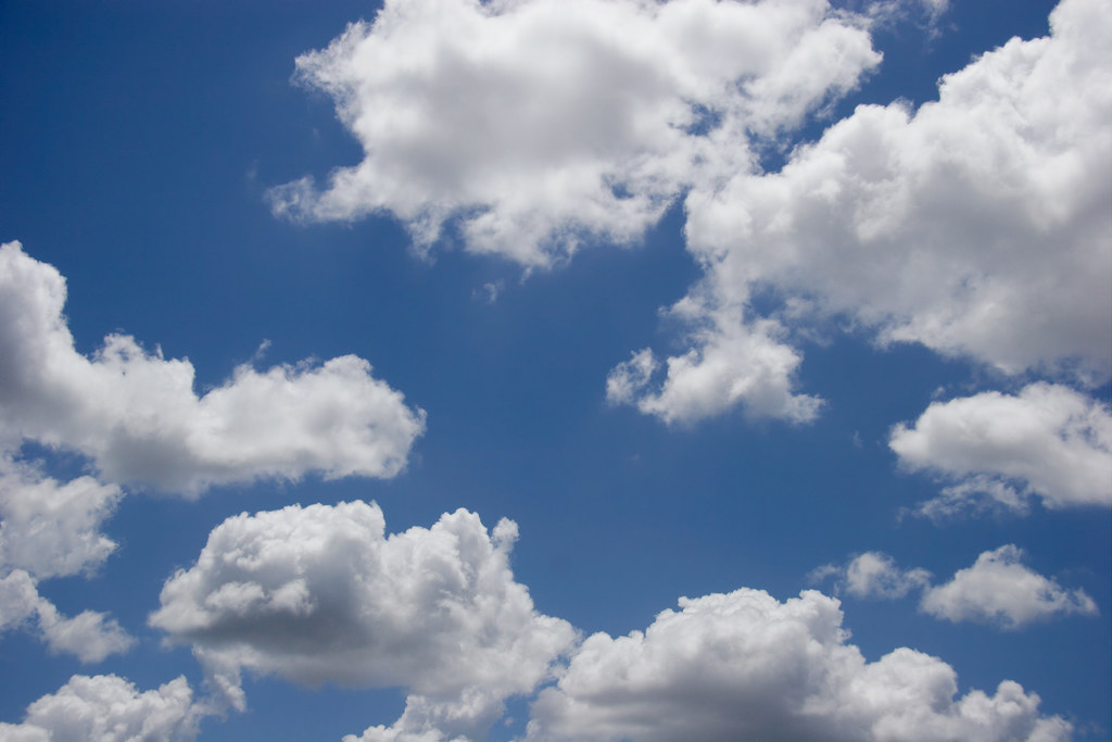 Blue skies with fluffy white clouds.