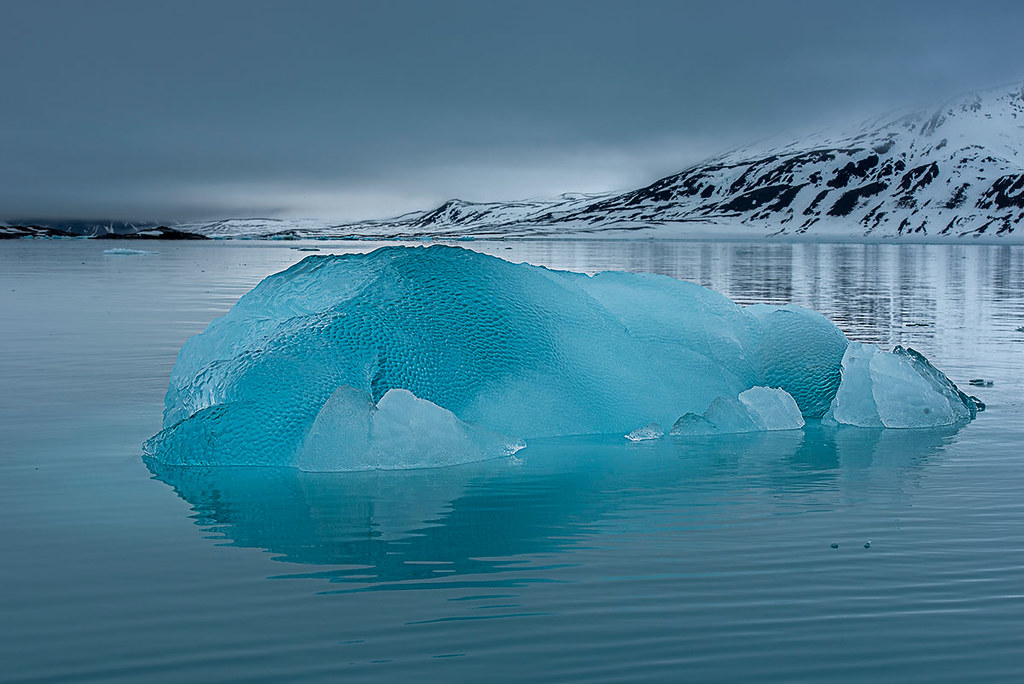 Iceberg floating in a serene blue ocean