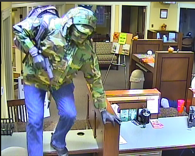Image of a masked robber in a mall or workplace.