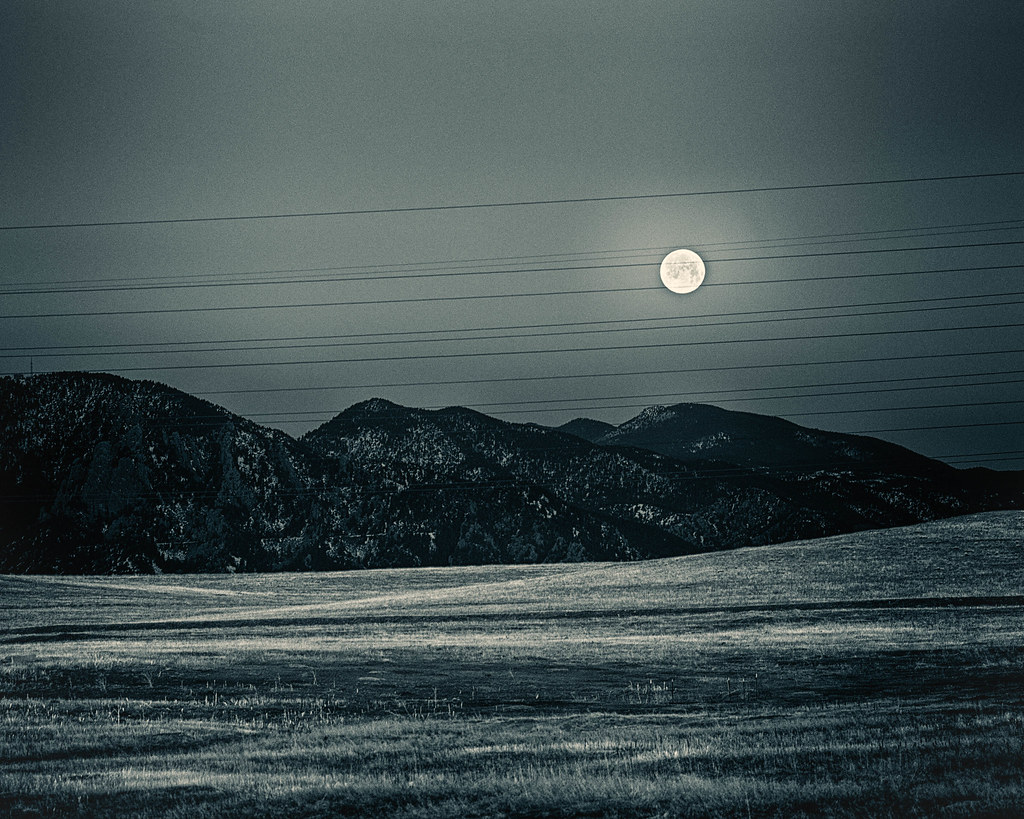 Moon setting over a serene landscape.
