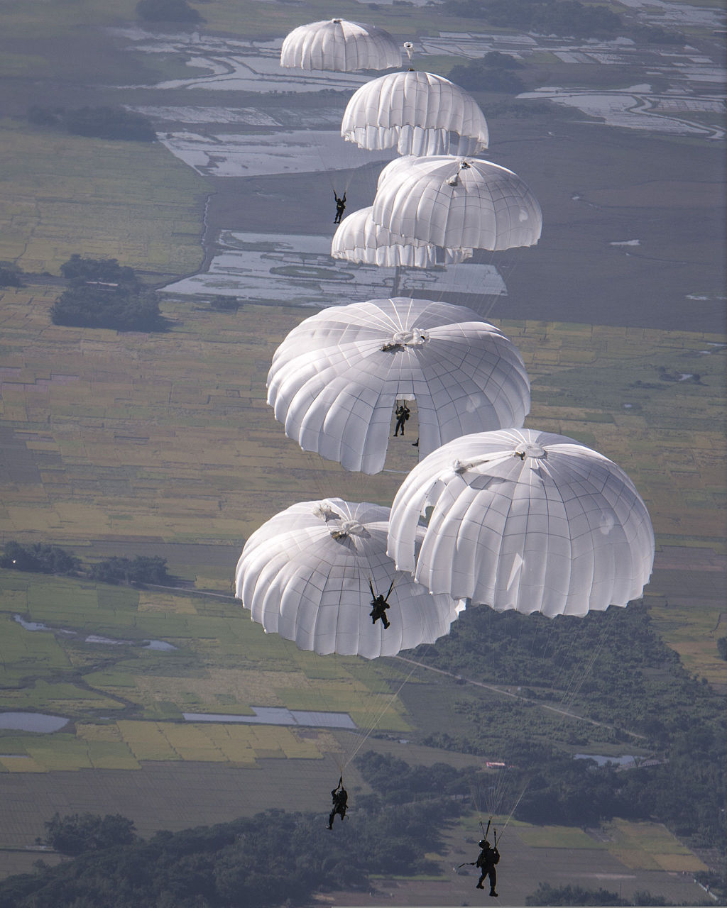 Parachute descending into a body of water.