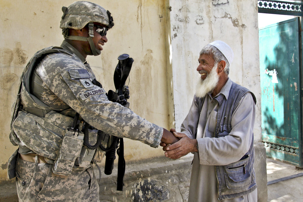 Soldiers shaking hands in a peaceful setting.